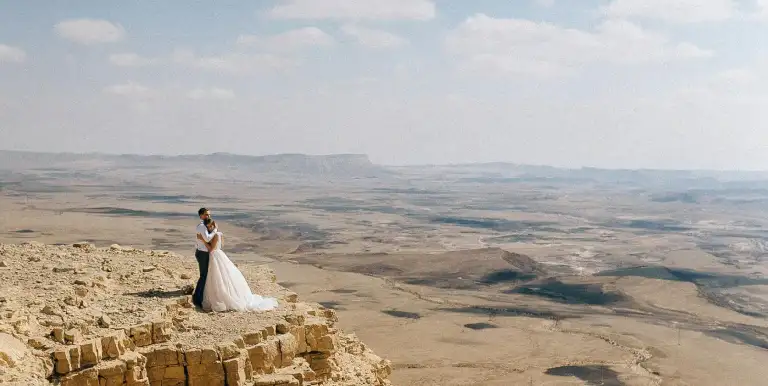 Novios_Mosaico_Pareja novios abrazados sobre precipio del desierto.webp - Pangea Viajes